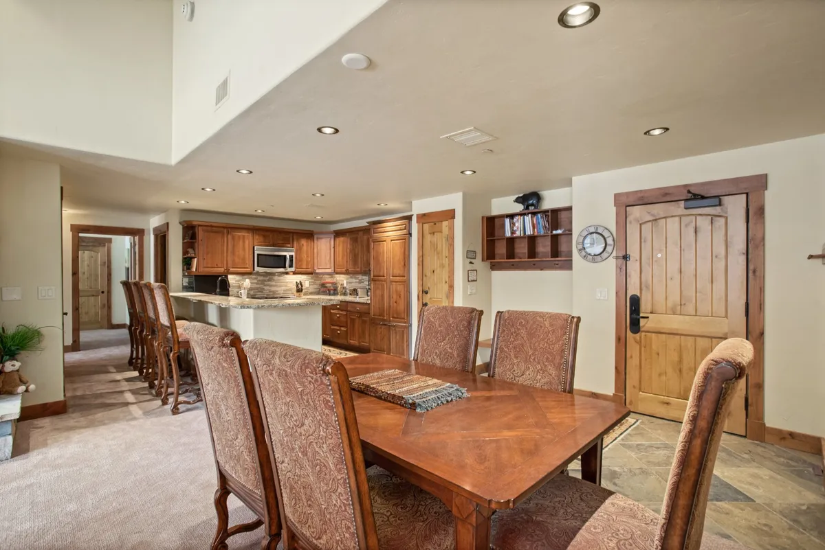 A cozy entryway with a clear view of the dining table, kitchen area, wooden cabinetry, and entry door. The space feels welcoming and functional, ideal for arrivals and departures, and shows how the entry flows into the heart of the home.
